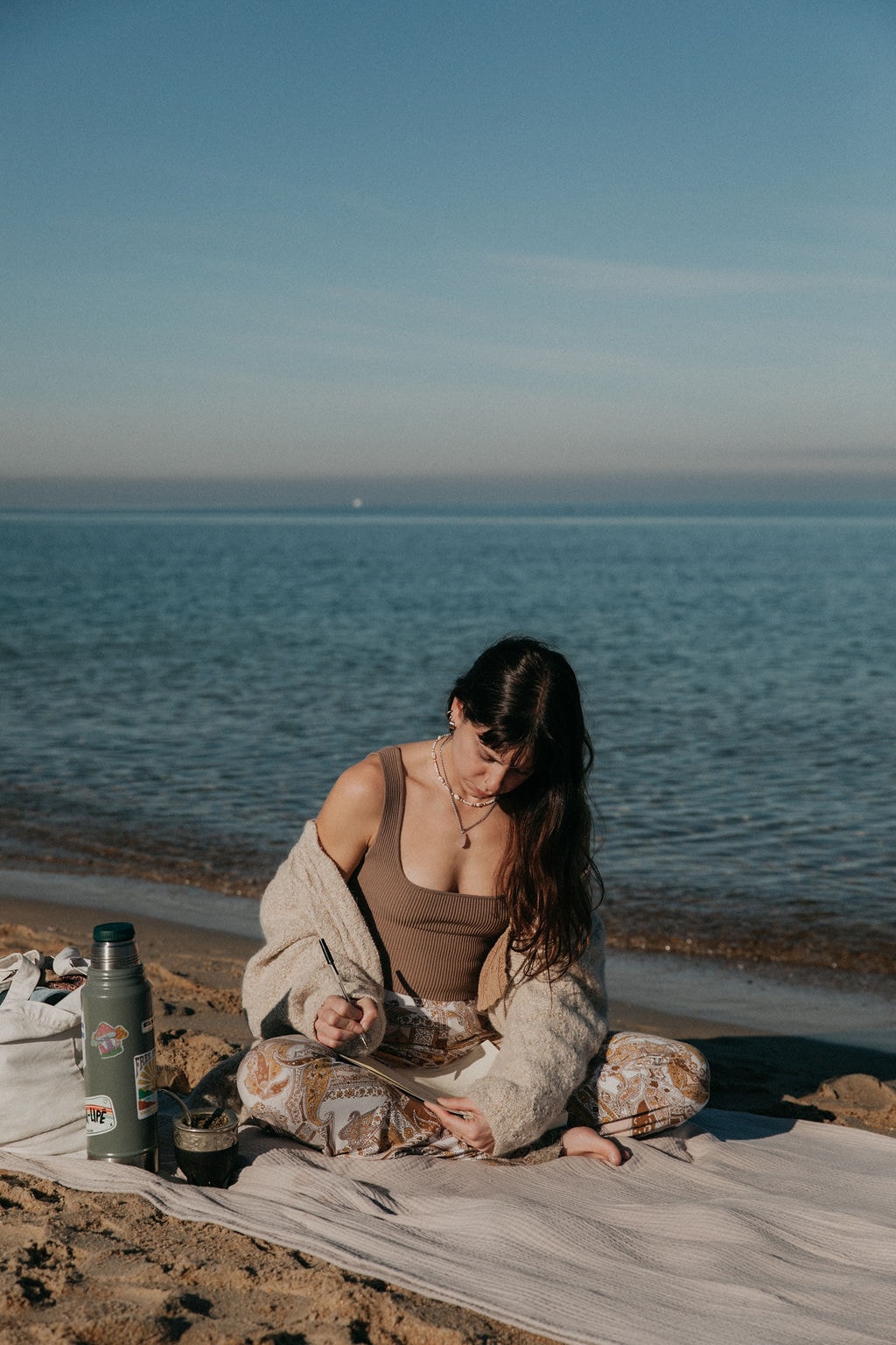 Sulli sitting at the beach writing in her journal