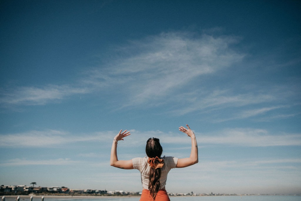 Sulli facing away with arms raised to the sky